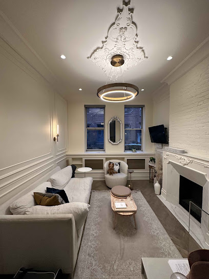 Freshly painted living room with an ornate ceiling medallion, modern round chandelier, white fireplace, and neutral sofa